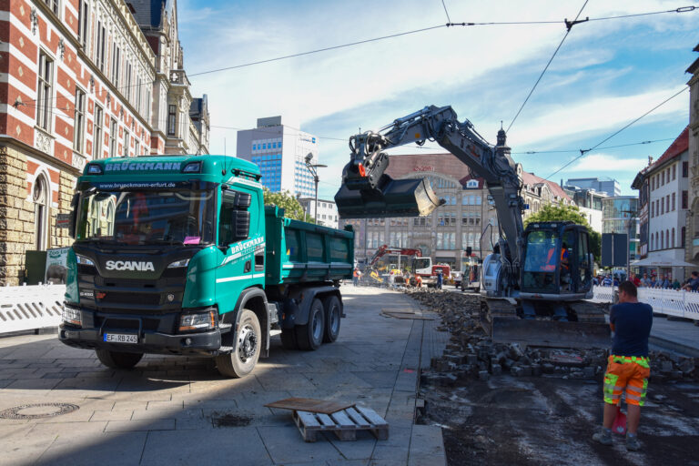 Kipper und Bagger bei Straßenbauarbeiten in der Stadt